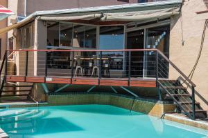 a building with a balcony and a swimming pool at Ramasibi Guest Services in Panorama