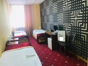 Zimmer mit 2 Betten und einem Schreibtisch mit einem Computer in der Unterkunft Davidov Inn in Kasan