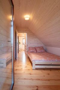 Łóżko w pokoju z drewnianą podłogą w obiekcie Mazurska Przystań w mieście Giżycko