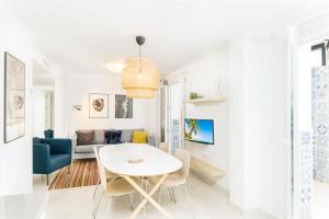 un soggiorno bianco con tavolo e divano di Suite Homes La Victoria a Málaga