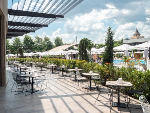 een rij tafels en stoelen op een patio bij Aqua Paradise Resort & Aqua Park in Nesebar