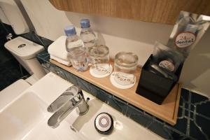 un bagno con un lavandino e un bancone con bottiglie d'acqua e bicchieri di Hotel Monopoli a Giacarta