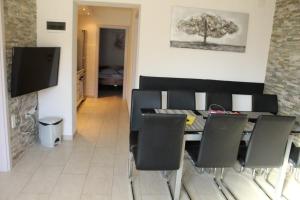 a dining room with a table and chairs and a television at Apartment Pirović in Turanj