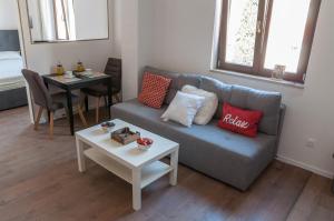 ein Wohnzimmer mit einem Sofa und einem Tisch in der Unterkunft Checkpoint apartments Mostar in Mostar