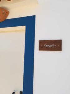 un cartel de madera en una pared con una raya azul en Quinta do Maranhão en Lagos