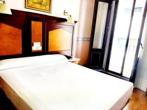 a bedroom with two white beds and a window at Hosteria Sara by gaiarooms in Salamanca