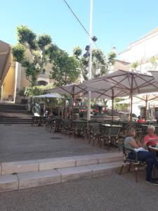 zwei Personen, die auf einer Terrasse im Freien auf Stühlen sitzen in der Unterkunft LA GRANDE MAISON centre in Bandol + 15 Fotos