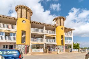 un edificio con dos torres con un coche aparcado delante en Best House Rubi, en Playas de Orihuela