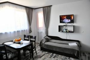 um quarto de hotel com uma cama e uma mesa com uma mesa em Ski Apartment Boyika Iglika 2 em Borovets