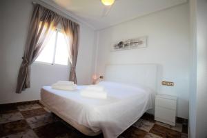 biała sypialnia z łóżkiem i ręcznikami w obiekcie Best House Rubi w mieście Playas de Orihuela +35 zdjęć