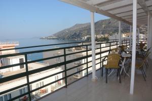 a balcony with a table and chairs and the ocean at Hotel Loutraki in Loutraki