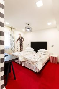 1 dormitorio con 1 cama grande y alfombra roja en Lol et Lola Hotel, en Cluj-Napoca