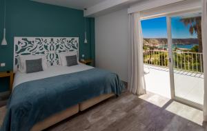 a bedroom with a bed and a large window at Mareta View - Boutique Bed & Breakfast in Sagres
