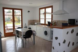 een keuken met een tafel en een wasmachine bij Appartement au calme à Hendaye in Hendaye