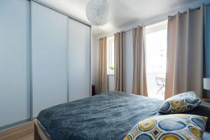 a bedroom with a bed and a large window at Chez Emile Private 5 star 3 room flat and in-door Pkg in Nitra