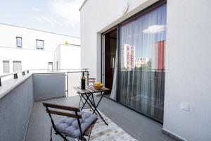 a balcony with a table and chairs on a balcony at Chez Emile Private 5 star 3 room flat and in-door Pkg in Nitra