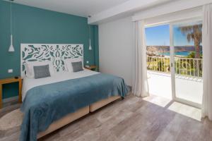 a bedroom with a large bed and a large window at Mareta View - Boutique Bed & Breakfast in Sagres
