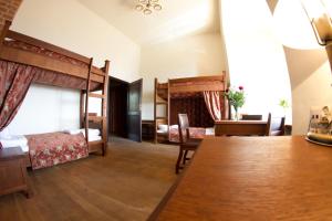 a bedroom with two bunk beds and a table and chairs at Zamek Golubski in Golub-Dobrzyń