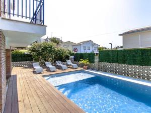 una piscina con tumbonas junto a una casa en Can Pinemar, en Pineda de Mar