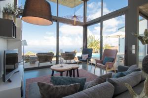 a living room with a couch and chairs and a tv at BLUE Casa by VILLA HAHN in Puntagorda