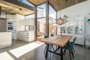 a kitchen and dining room with a wooden table and chairs at BLUE Casa by VILLA HAHN in Puntagorda