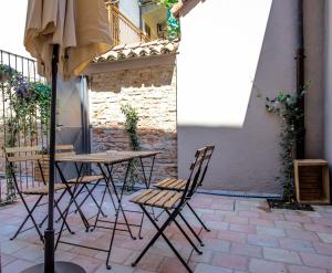 a table and chairs and an umbrella on a patio at La Canonica - charming self-catering apartments in Nizza Monferrato in Nizza Monferrato