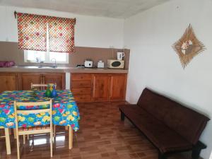 eine Küche mit einem Tisch und einer Bank in einem Zimmer in der Unterkunft Hebergement Vue Sur Mer in Rodrigues Island
