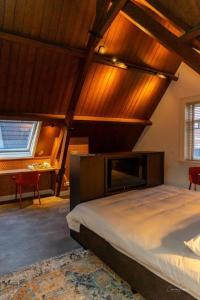 a bedroom with a large bed with a wooden ceiling at Slot Oostende in Goes