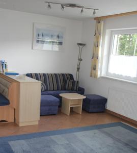 sala de estar con sofá azul y mesa en Ferienwohnung Mattle, en Jerzens