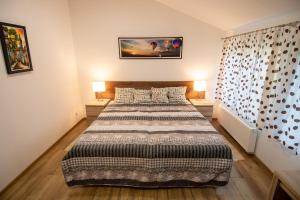 a bedroom with a large bed with two lamps at Apartamenty Podwarszawskie in Stara Wieś