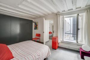 - une chambre avec un lit et une grande fenêtre dans l'établissement Saint Germain dès Pres Paris VI° - Unit 003, à Paris