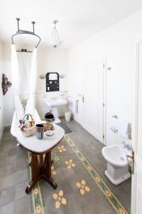 y baño con lavabo, aseo y mesa. en Cascina Vecchia Bellaria B&B en Bellaria-Igea Marina