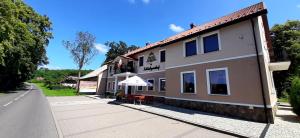 un edificio con una mesa al lado de una calle en Zajazd Zamkowy - Schloßgasthof, en Krąg