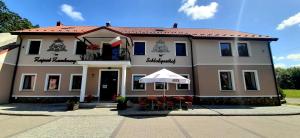 a large building with an umbrella in front of it at Zajazd Zamkowy - Schloßgasthof in Krąg