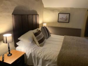 a bedroom with a large white bed with pillows at The Swan and Talbot in Wetherby