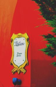 a sign on a red wall with a christmas tree at il Palazzo Rooms & Suites in Nafplio