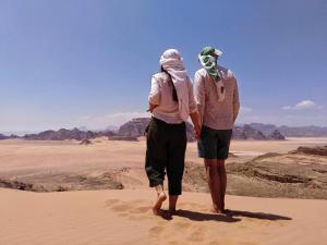 two people walking in the desert at MalakoRum in El Quweira