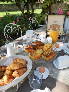 una mesa con un montón de pasteles y huevos. en Le Mas des Agapes en Beaucaire