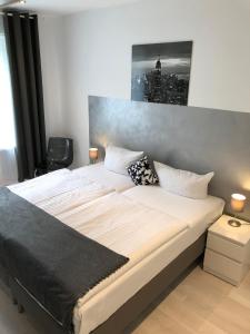 a bedroom with a large bed with a picture on the wall at Liberty Hotel Cologne in Cologne
