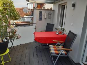 a red table and chairs on a balcony at Ferienwohnung Altstadtflair in Schweinfurt