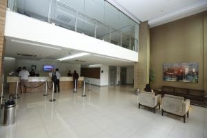 um lobby com pessoas em pé em um balcão em um edifício em Best Hotel Sobral em Sobral