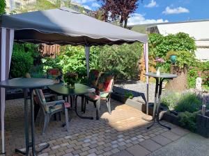 eine Terrasse mit Tischen und Stühlen unter einem Sonnenschirm in der Unterkunft Liberty Hotel Cologne in Köln