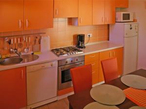 a kitchen with orange cabinets and a sink and a table at Cozy apartment Ernesto*good location*Rovinj in Rovinj