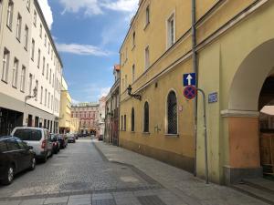 an empty street with cars parked on the sides of buildings at Studio @ Market Square Gliwice in Gliwice
