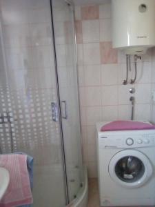 a washing machine in a bathroom with a shower at Holiday Home Zeljana in Kaprije