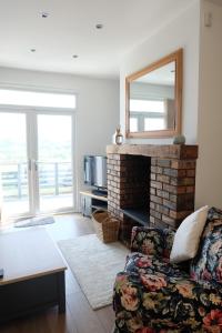 a living room with a fireplace and a mirror at 1 Saron Cottages in Llandudno