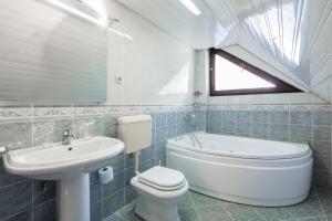 a bathroom with a toilet, sink and tub at Hotel Bistra, Resort Mavrovo in Mavrovo