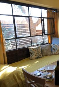 a room with a bed and a table and windows at Out of the Wilderness in Midreshet Ben Gurion