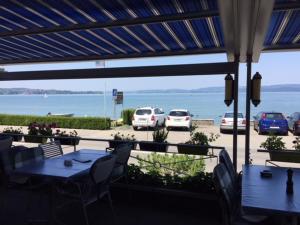 a patio with tables and chairs and a view of the ocean at Hotel Seestern in Berlingen
