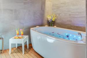 a bathroom with a tub with a side table at Hotel Pinija in Petrcane